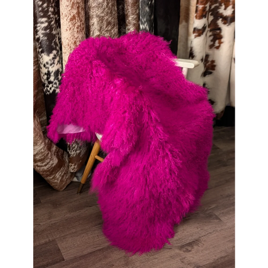 Vibrant hot pink Angus Oliver sheepskin throw on wooden chair