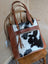 Brown leather and black and white real cowhide spacious oakley specks canvas tote bag with frayed edges and tassels