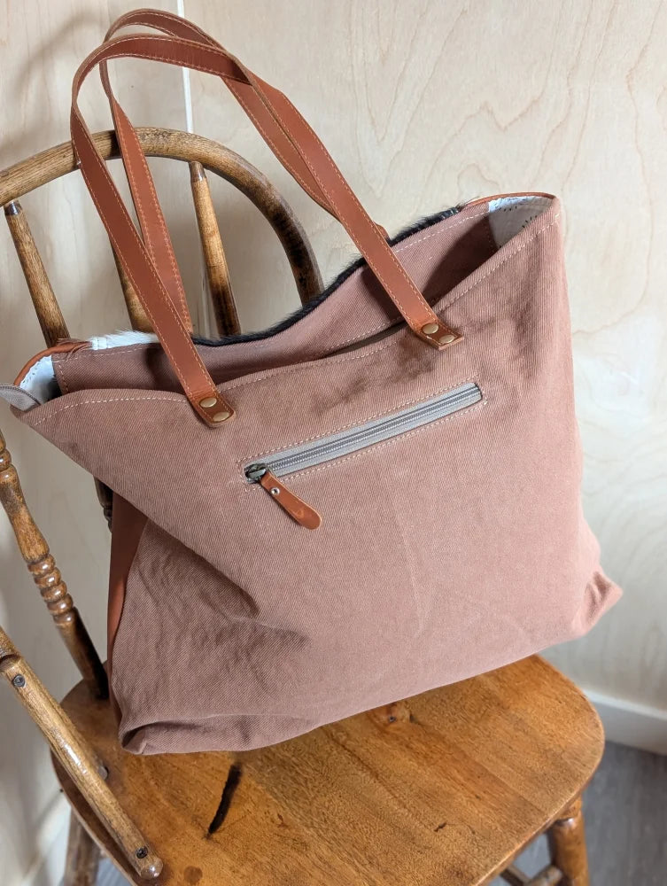A spacious oakley specks canvas tote bag in soft dusty rose with real cowhide tan leather handles and zipper pull