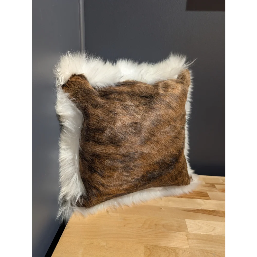 Brown and white fur throw pillow with plush textured surface made of cowhide merino sheepskin cushion