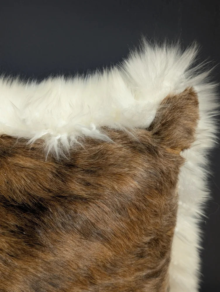Brown and white faux fur merino sheepskin cushion with plush textured surface in cowhide merino sheepskin style