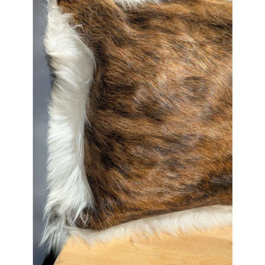 Brown and white cowhide merino sheepskin cushion with plush natural fur texture and one of a kind design