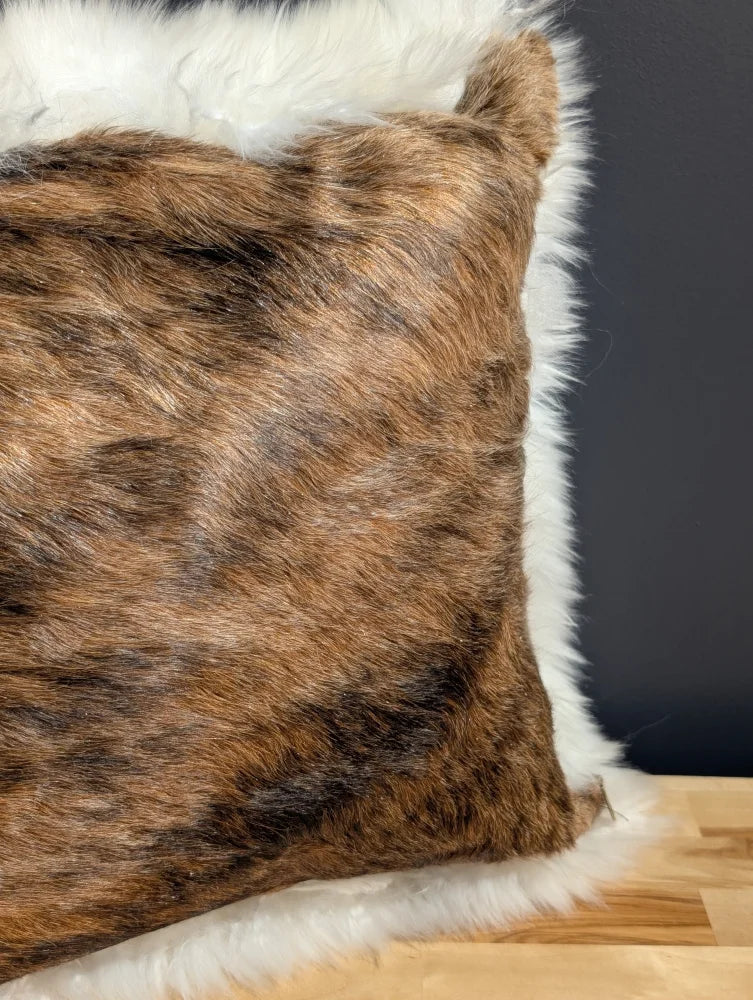 Brown and black cowhide merino sheepskin cushion with plush white fur trim for cozy home decor
