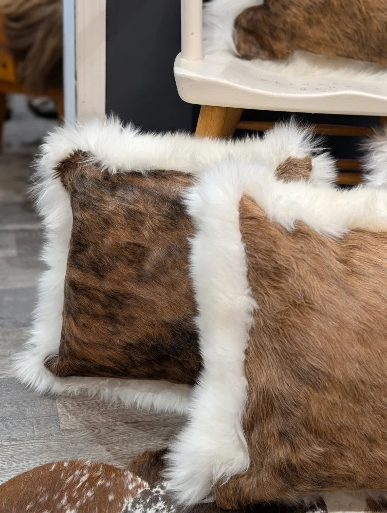 Brown and white cowhide merino sheepskin cushion with fluffy natural fur trim for cozy home decor