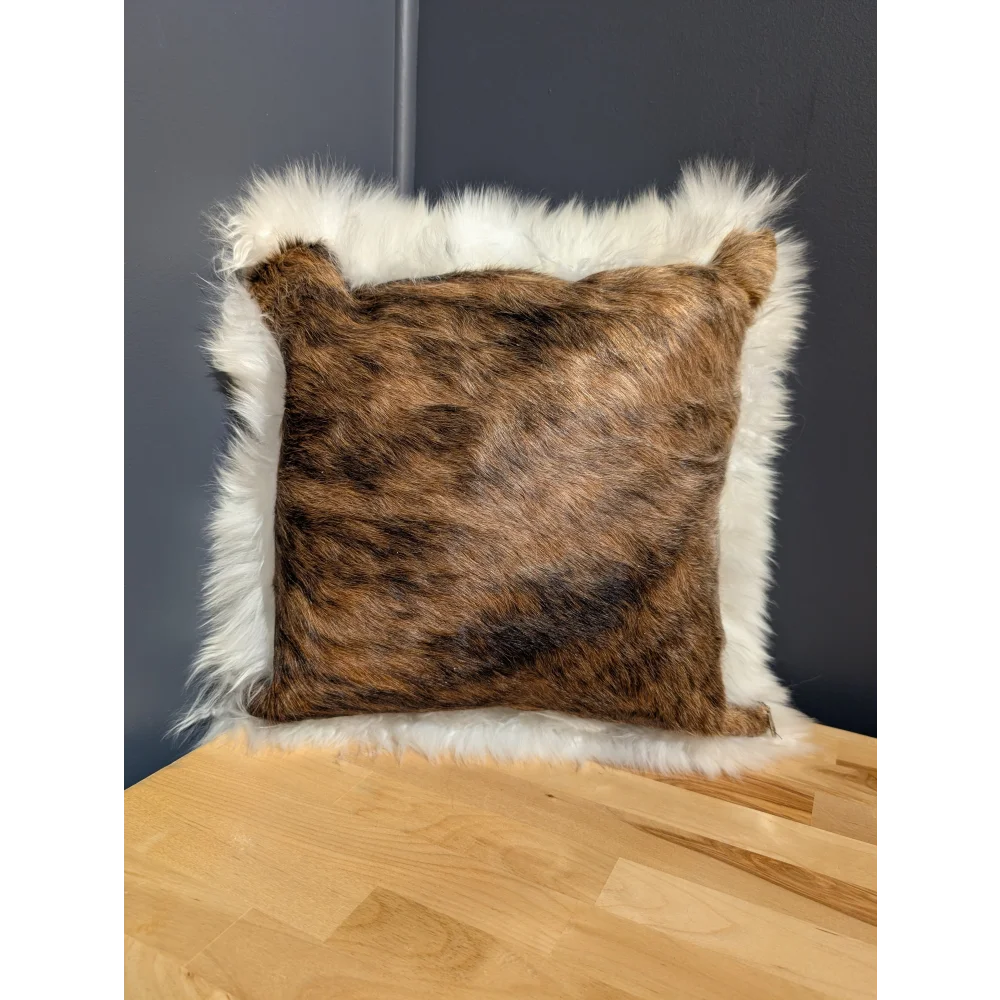 Brown and white plush cowhide merino sheepskin cushion with a soft textured surface perfect for cozy decor