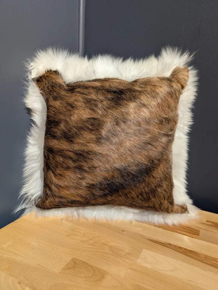 Brown and white plush cowhide merino sheepskin cushion with a soft textured surface perfect for cozy decor