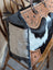 The sunflower weekender bag is a cartwright hand-tooled bag with hair-on hide cowhide, distressed denim, and zippered pocket