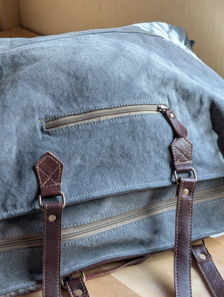 Blue denim sunflower weekender bag with brown leather straps and zippered pocket inspired by cartwright hand-tooled bag