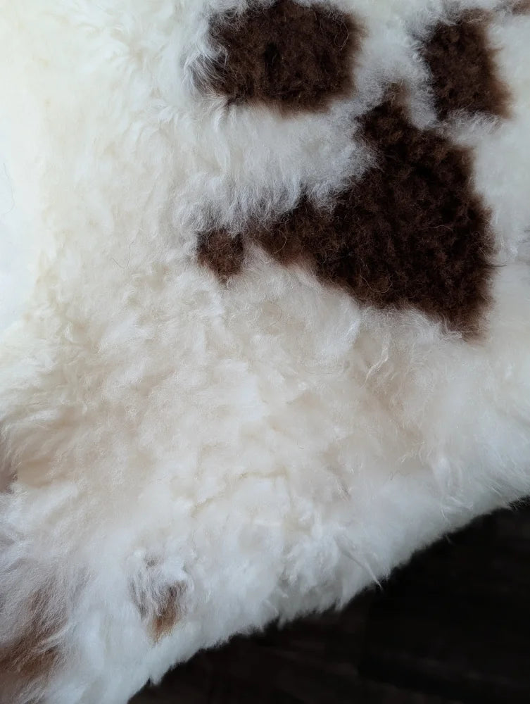 White and brown tibet highland spotted grade a- sheepskin rug with curly fur and paw print design
