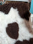 A plush grade b sheepskins rug with a soft white base and rich brown patches in highland spotted style
