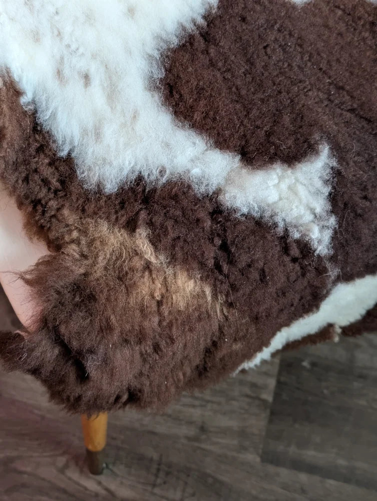 Brown and white highland spotted grade b sheepskin rug with plush curly texture perfect for cozy decor