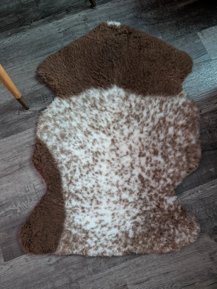 Brown and white tibet highland spotted grade a- sheepskin rug with a natural fluffy texture