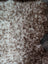 A plush cream and brown speckled faux fur throw blanket with soft texture made from grade a- tibet highland spotted sheepskins