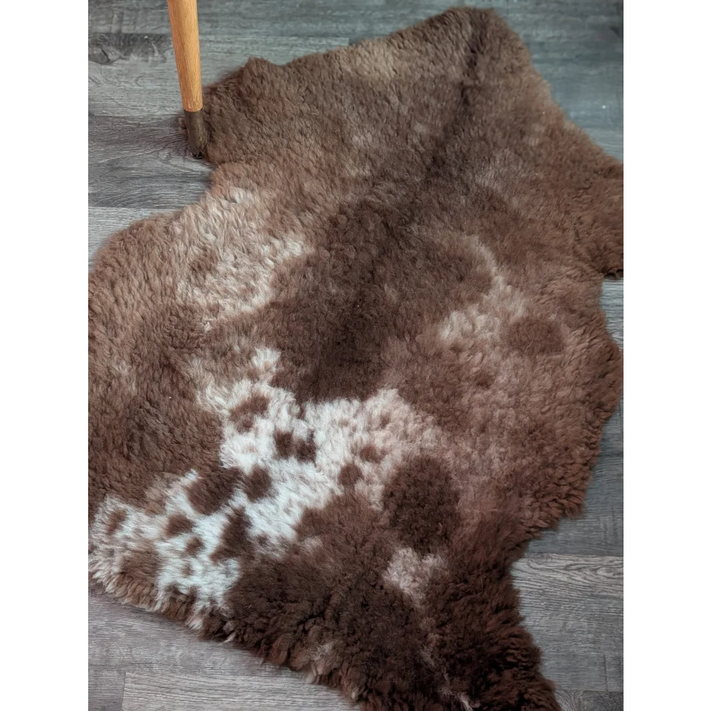 A plush tibet highland spotted grade a- sheepskin rug in brown and white with a natural fluffy texture