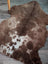 A plush tibet highland spotted grade a- sheepskin rug in brown and white with a natural fluffy texture