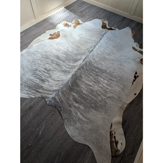 Large cowhide rug with gray and white marbled pattern and brown edge patches extra large cowhide perfect for decor