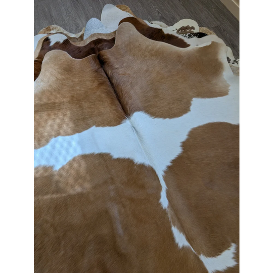 Large brown and white cowhide rug with natural fur texture perfect for beautiful rugs and extra large cowhide decor