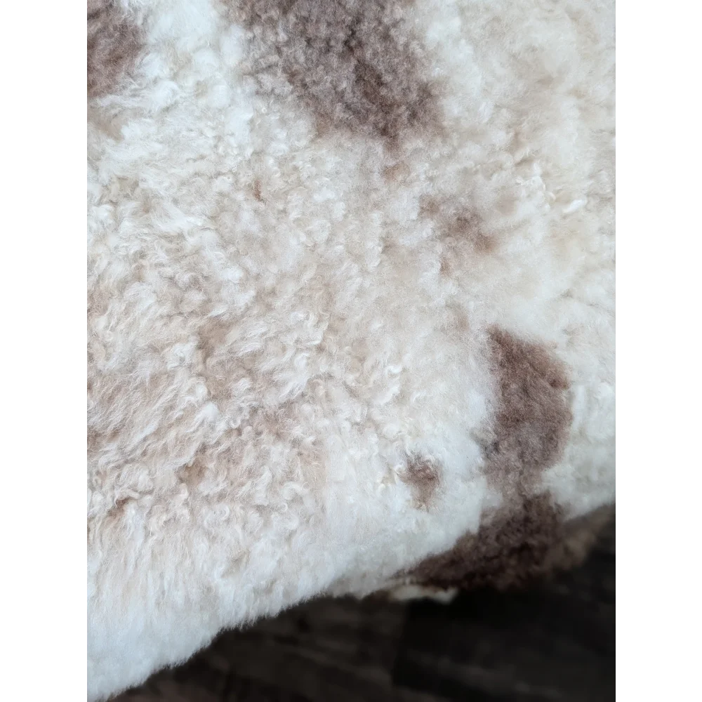 A cream highland spotted sheepskin rug with soft curly fibers and brown patches grade a tibet highland spotted