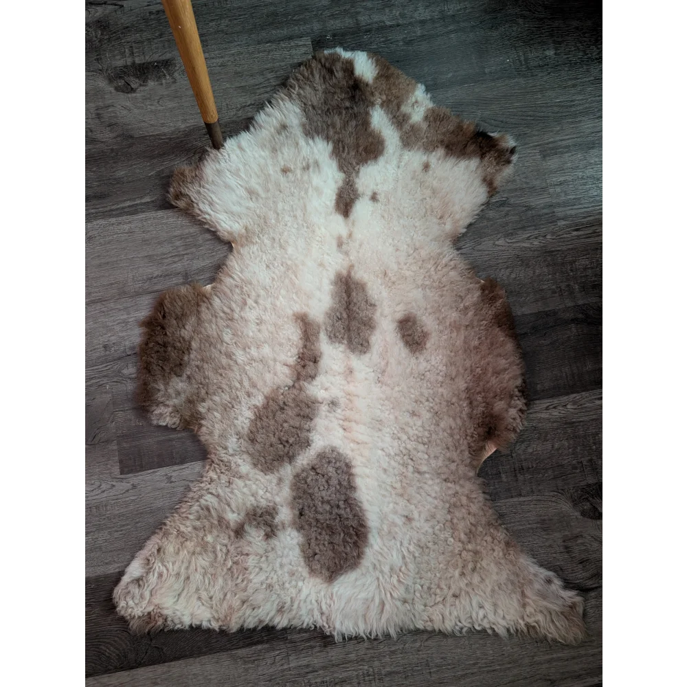 A plush grade a- sheepskin rug with a soft white base and brown splotches from tibet highland spotted collection