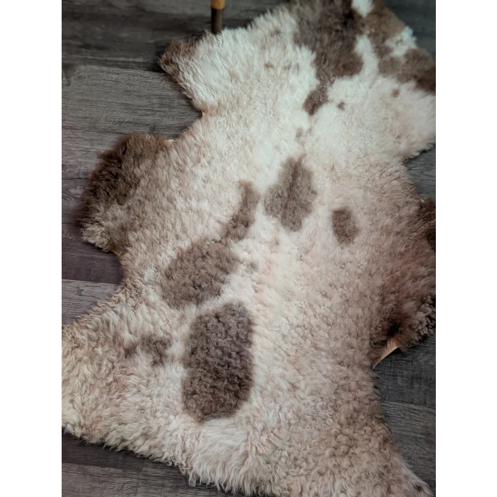 A plush grade a- sheepskin rug with soft white and brown fur in a natural tibet highland spotted pattern