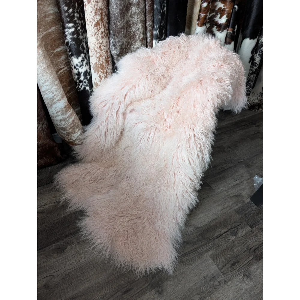 Blush pink 71x47 inch shaggy sheepskin rug on wooden floor