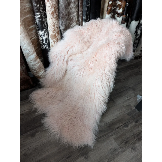 Blush pink 71x47 inch shaggy sheepskin rug on wooden floor