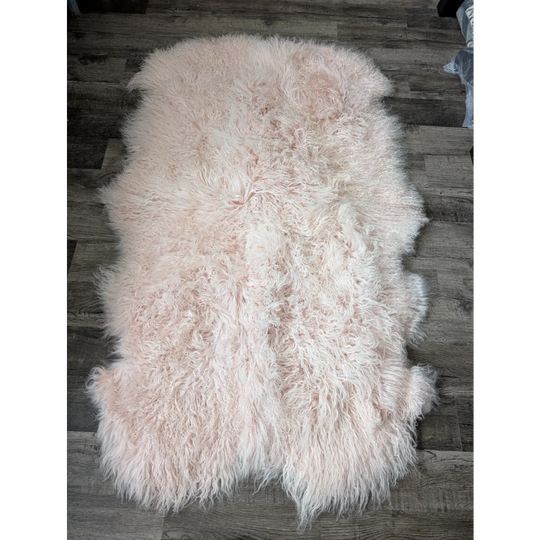 Blush pink Angus Oliver sheepskin rug, 71x47 inches, fluffy on wood floor