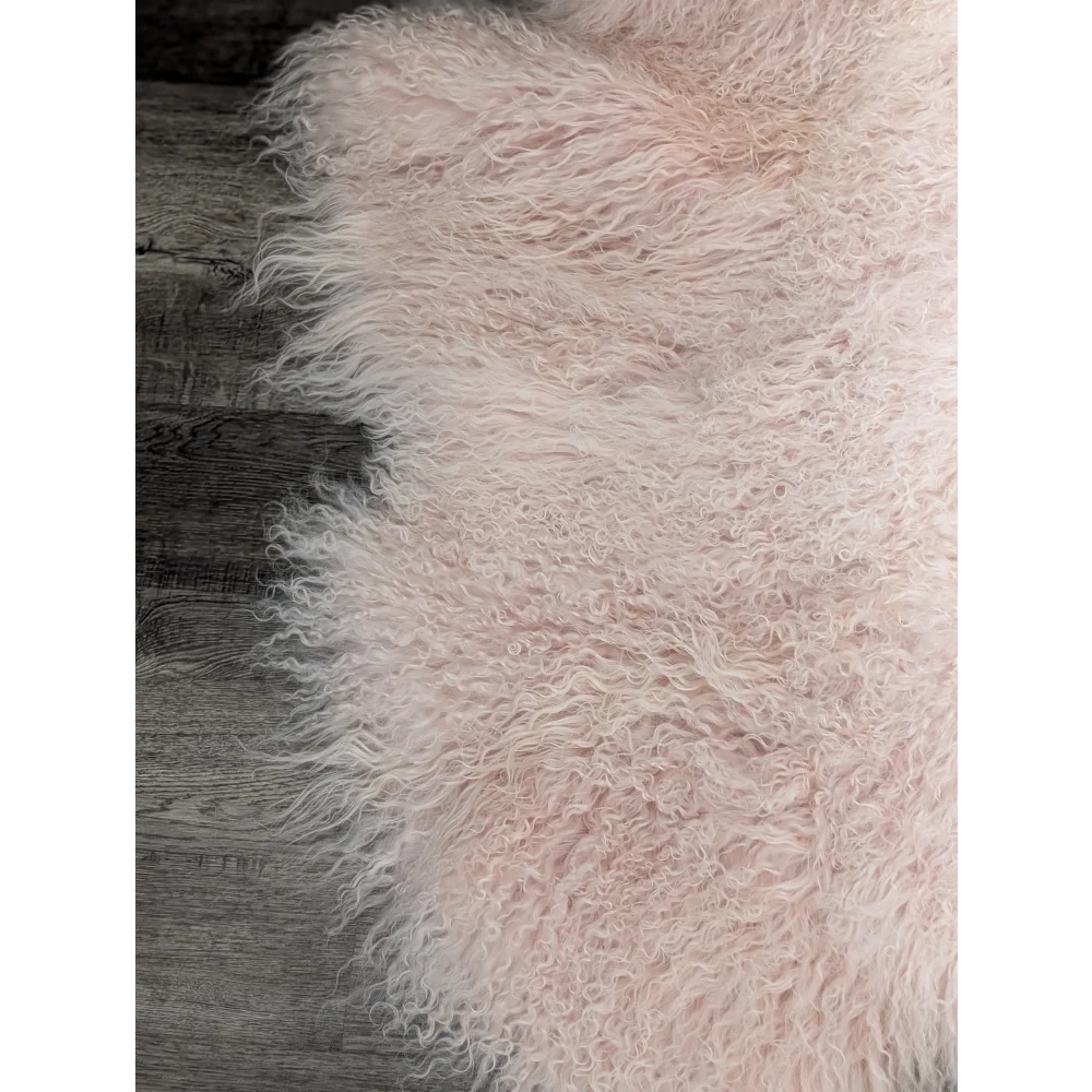 Blush pink Angus Oliver sheepskin rug on wooden floor