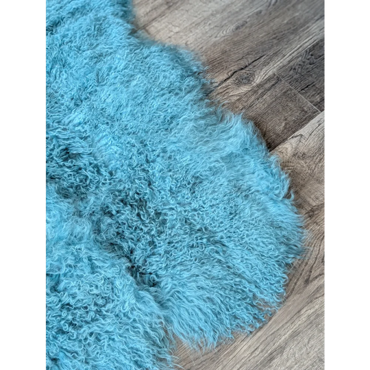 Gorgeous aqua quad sized Mongolian sheepskin rug on wood floor