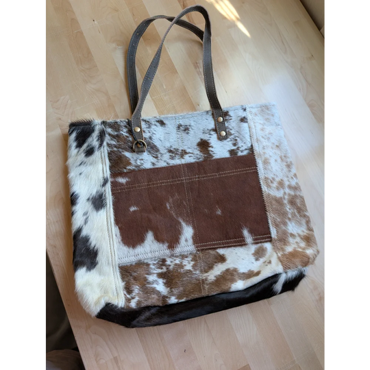 Brown and white cowhide patchwork tote bag with leather handles made from real cowhide perfect for daily use