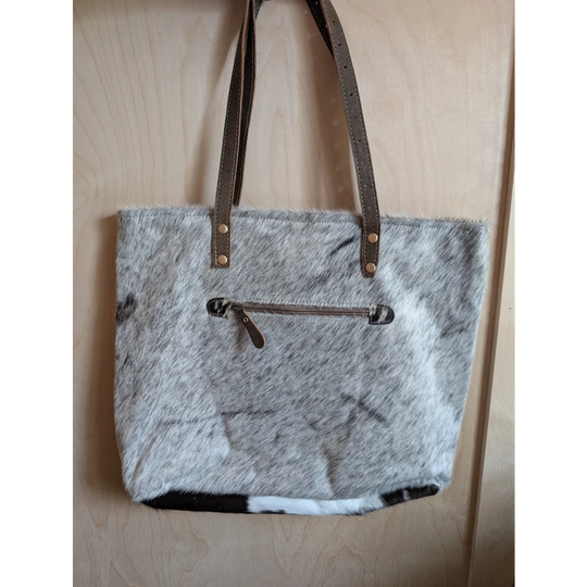 Gray and white real cowhide tote bag with brown leather straps and front zipper pocket from cowhide rugs collection