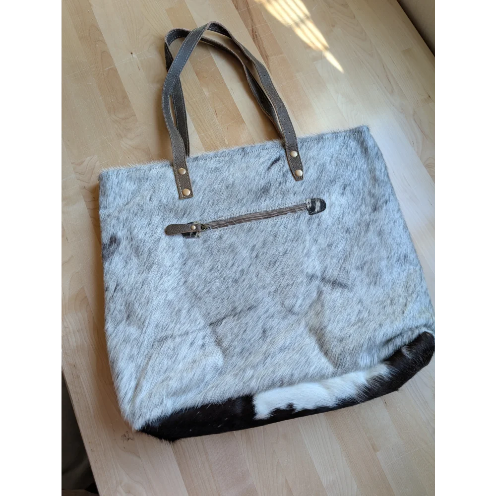 Gray and white real cowhide tote bag with brown leather handles and zipper closure from the 
