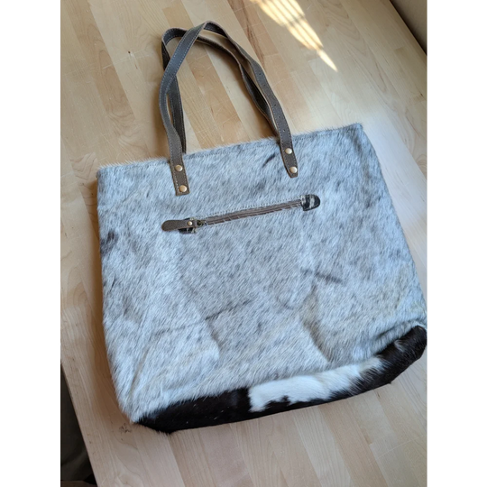 Gray and white real cowhide tote bag with brown leather handles and zipper closure from the 