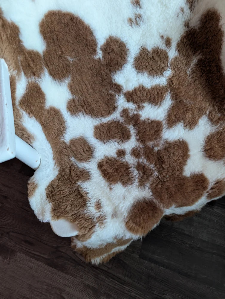 Brown and white spotted highland spotted grade b sheepskin rug with plush soft faux fur texture