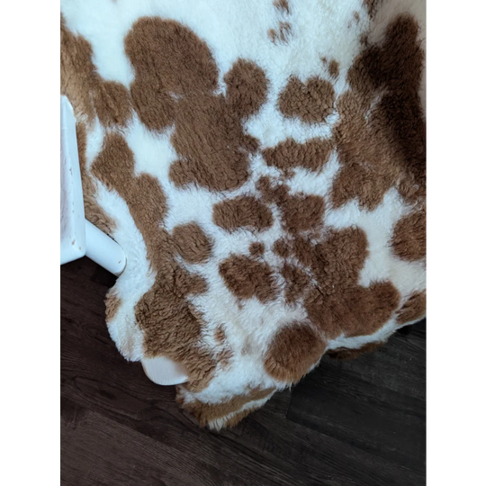Brown and white spotted highland spotted grade b sheepskin rug with plush soft faux fur texture