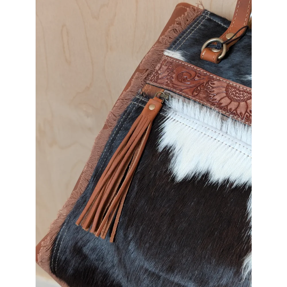 Black and white real cowhide oakley specks canvas tote bag with brown leather and floral strap, spacious with tassel zipper
