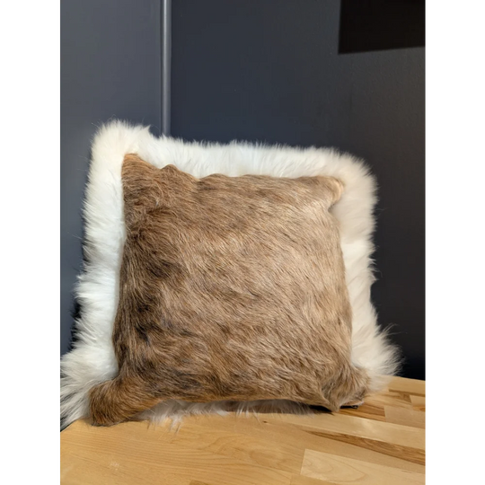 A square plush cushion in natural brown cowhide with soft white merino sheepskin trim for cozy decor