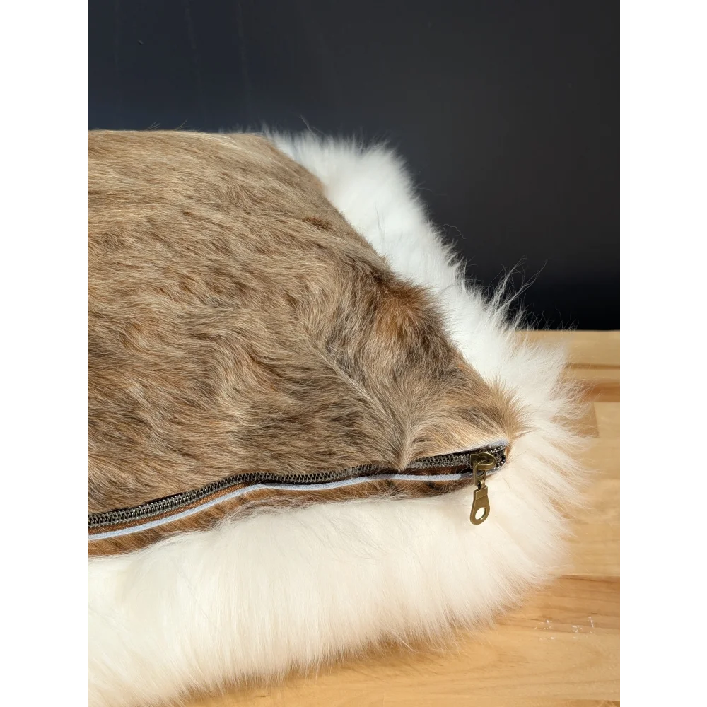 Faux fur throw pillow with brown and white fluffy cowhide merino sheepskin exterior and side zipper closure