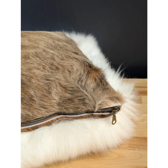 Faux fur throw pillow with brown and white fluffy cowhide merino sheepskin exterior and side zipper closure