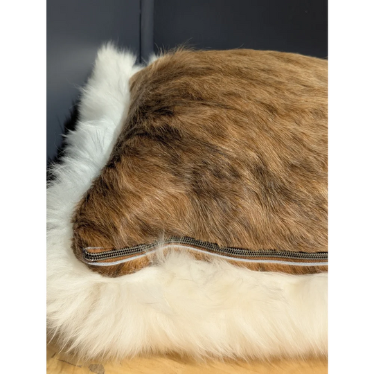 Brown faux fur merino sheepskin cushion with white fluffy trim and visible zipper for cozy cowhide merino sheepskin use