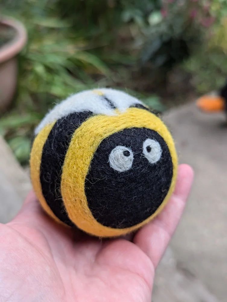 Cute yellow black wool bumble bee dryer ball with googly eyes