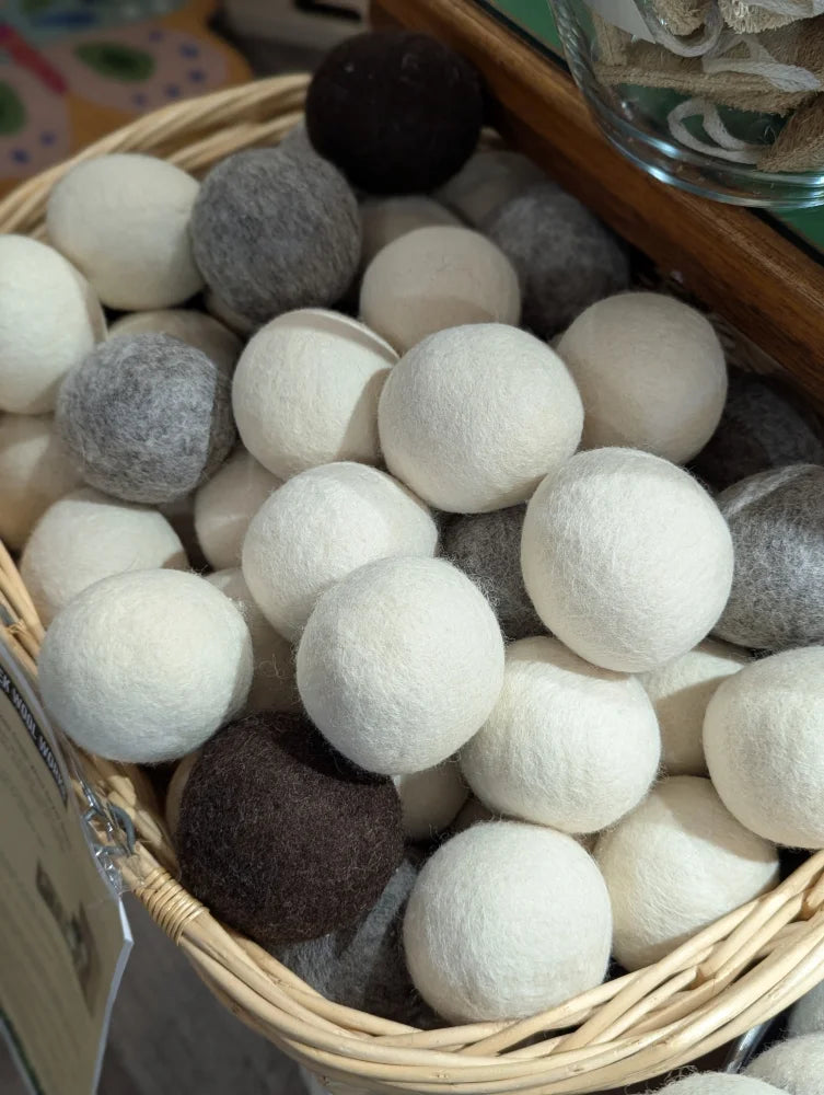 A basket with white and gray fluffy wool dryer balls made from pure merino by moss creek wool