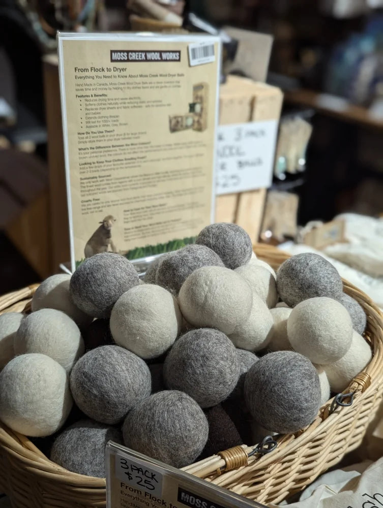A basket of soft wool dryer balls in white and gray shades made from pure merino by moss creek wool