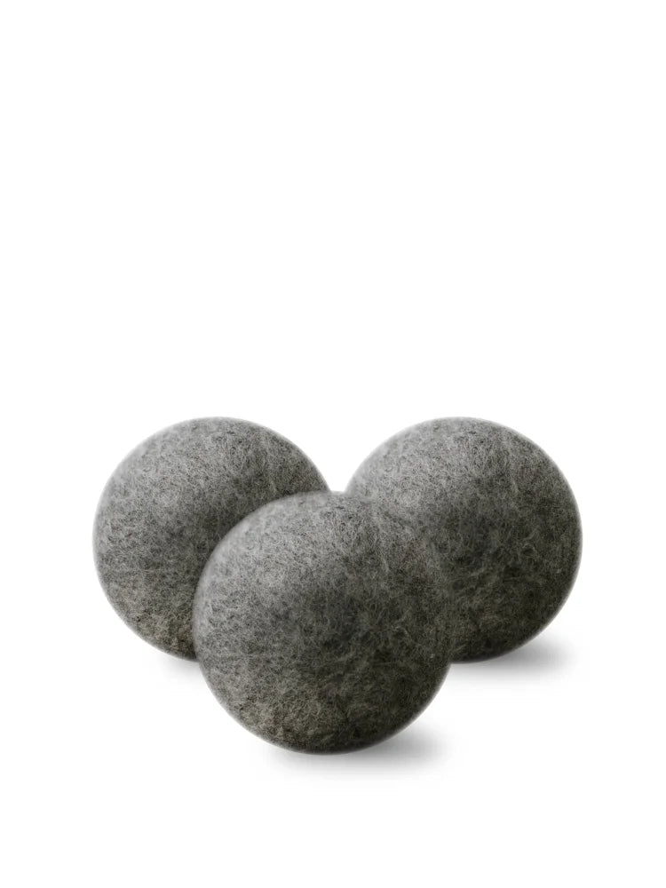 Three matte gray wool dryer balls with soft felt texture for eco friendly laundry use