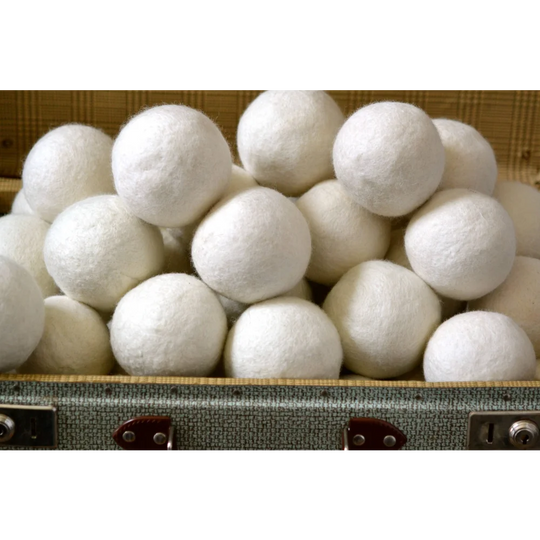 White fluffy wool dryer balls nestled in a vintage suitcase from 3 wool dryer balls wht gry brn set