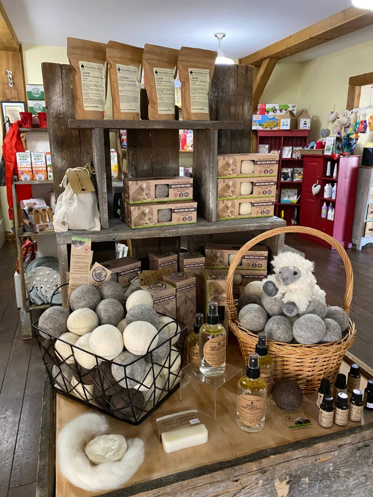 Woven wicker basket with gray wool dryer balls and a plush white sheep toy for natural dryer balls use