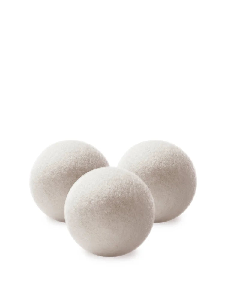 Three off-white fluffy wool dryer balls made of felt for natural laundry drying and softening