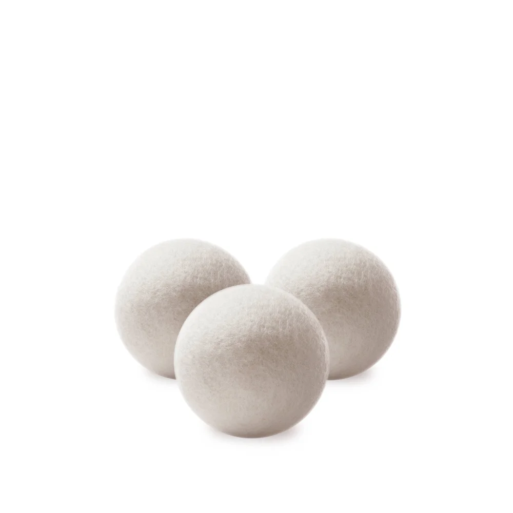 Three off-white fluffy wool dryer balls made of felt for natural laundry drying and softening
