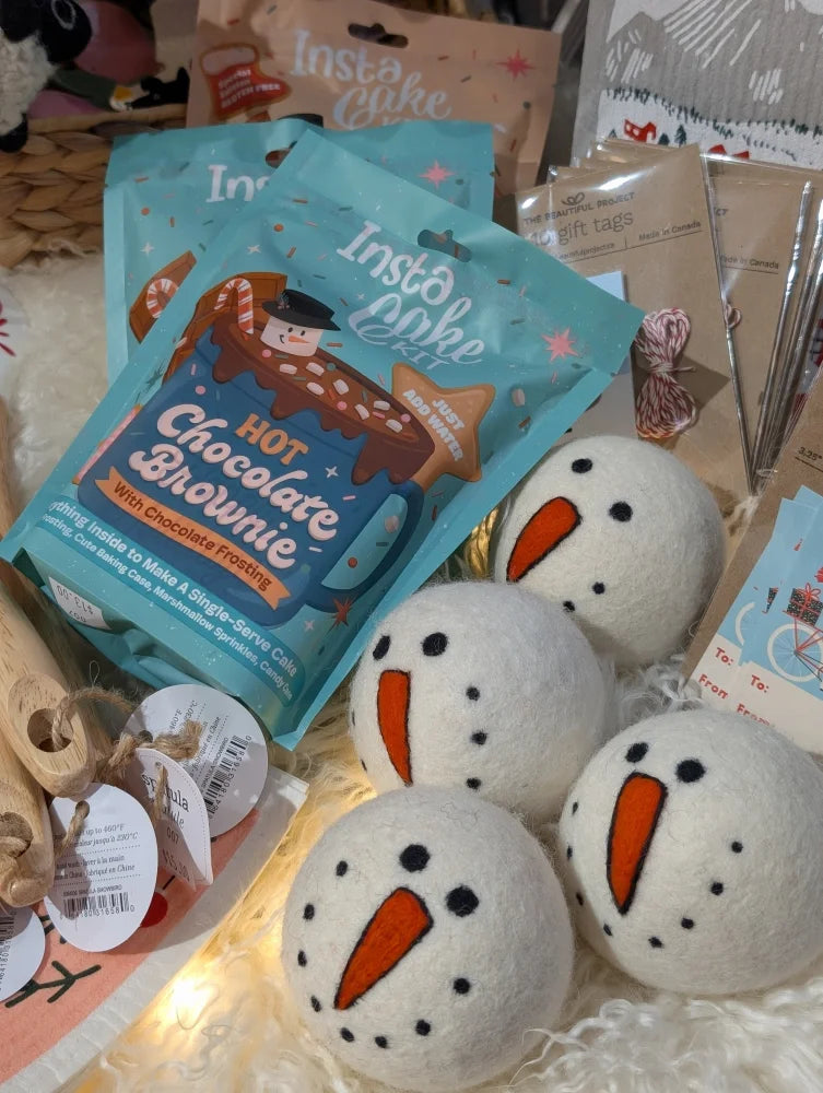 Cute wool snowman dryer balls with carrot noses, black eyes, and sheepskin fluff