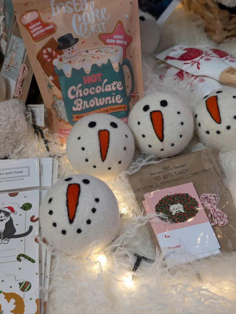 White ceramic snowman dryer balls with carrot noses and black eyes